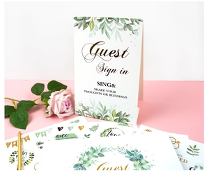 Detailed wedding guest book sign set with elegant green leaf patterns and gold pen