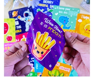 Detailed view of colorful glossy motivational lunch cards with cute cartoon illustrations