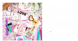 Close-up of DIY scrapbook kit featuring golden heart frames and colorful alphabet stickers