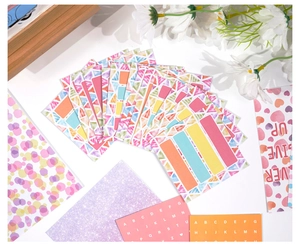Detail of DIY journal kit featuring bronzing stickers and colorful scrapbooking accessories