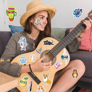 Detail of colorful VSCO stickers featuring cartoon animals and summer elements on a guitar