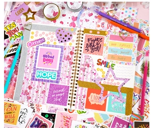 Flat lay of pink and purple DIY scrapbooking set with notebook, stickers and glitter tape