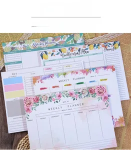 Detailed top view of various colorful weekly planner pads with floral and watercolor designs