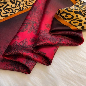 Detailed macro view of leopard print silk scarf with floral patterns on plush background