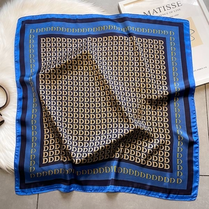 Foulard quadrato in seta blu e nero con stampa di lettere D dorate su tappeto soffice