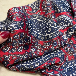 Detailed macro view of vintage paisley silk scarf with glossy texture and floral patterns