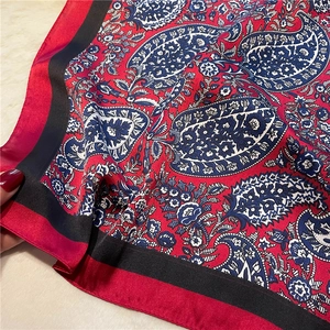 Detail of red and navy paisley silk scarf with elegant pattern and silky texture