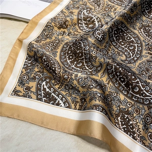 Detail of vintage paisley silk square scarf with elegant yellow and white floral patterns