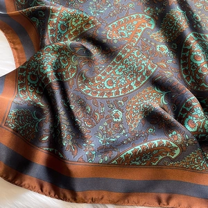 Macro detail of silk-like paisley print scarf with smooth texture and neat stitching