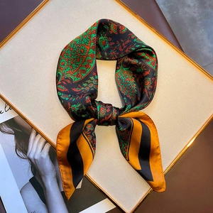 Detail of vintage paisley silk scarf featuring orange and black stripes and glossy texture