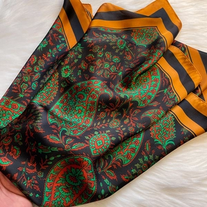Detail of vintage paisley print silk scarf on plush white faux fur background