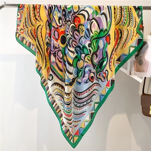 Close-up of a vibrant 110cm silk-like scarf with abstract graffiti patterns on a metal rack
