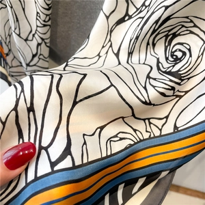 Detailed close-up of breathable lightweight silk scarf fabric with floral rose patterns