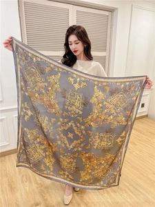 Detailed view of grey silk shawl featuring elegant golden royal crests and floral motifs