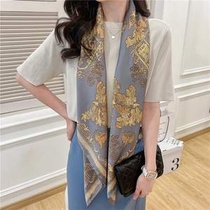 Detail of blue and gold vintage floral silk scarf styled with luxury packaging