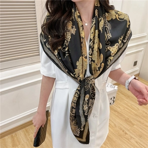 Detailed shot of large 110cm silk-satin scarf featuring baroque patterns in black and gold