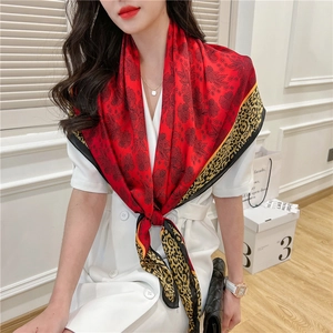 Detail of red floral silk scarf with leopard print borders and luxurious smooth texture
