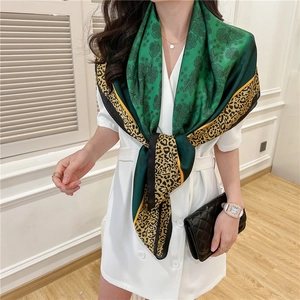 Detail of silk-feel scarf featuring green floral center and leopard print border texture