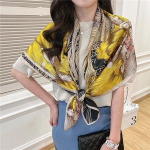 Detail of elegant mustard yellow silk-feel square scarf with abstract floral print