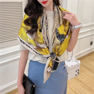 Close-up of yellow and black floral silk scarf with elegant artistic pattern texture