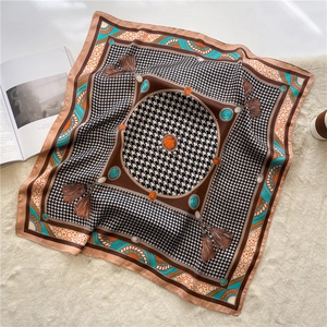 Detail of vintage silk scarf with houndstooth pattern and jewel print on plush background
