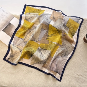 Detail of elegant silk square scarf with geometric patterns and deep blue hem decoration