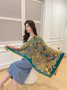 Detail of luxury baroque gold badge patterns on a teal silk scarf with yellow borders