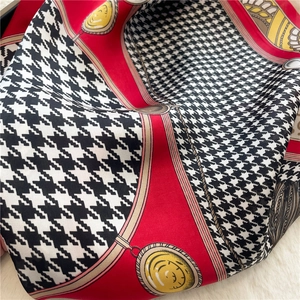 Detailed texture of silk scarf with houndstooth pattern and red borders on fur backdrop