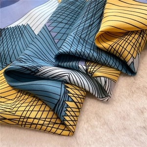 Detail of silk scarf showing smooth texture with yellow and blue geometric patterns