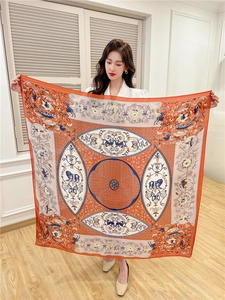 Detailed macro view of large square silk scarf featuring vintage lion totem and orange print