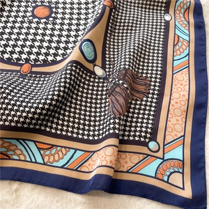 Detail of silk-feel scarf with houndstooth pattern and ornate jewelry motifs on fur
