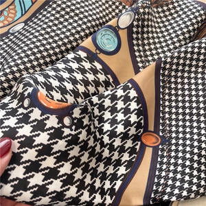 Detailed close-up showing houndstooth and chain patterns on silky square scarf fabric