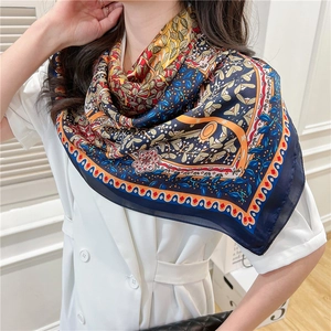 Close-up of vintage floral silk scarf with navy blue pattern and elegant lightweight texture
