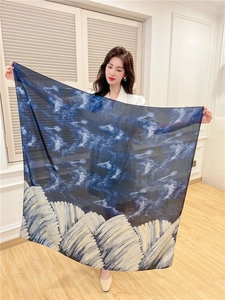Detail of a large blue silk-like scarf with white ink-style mountain pattern texture
