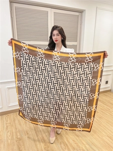 Flat lay view of a large square silk-like scarf featuring vintage geometric patterns