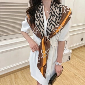 Close-up of geometric pattern silk scarf draped elegantly on a model's neck