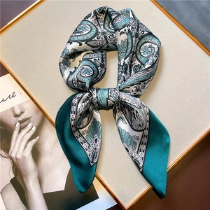 Detail of vintage paisley silk scarf knotted on a fashion magazine background
