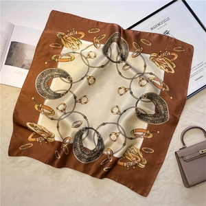 Detailed close-up of retro jewelry print silk scarf featuring chain patterns and glossy finish