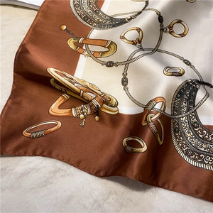 Detailed macro view of vintage chain patterns on a smooth silk square scarf