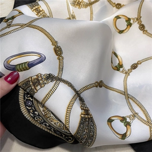 Detail of luxury chain print silk scarf showing white and black contrast fabric texture