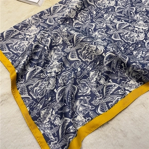 Vue détaillée d'une écharpe en soie bleu marine avec motifs de roses et d'oiseaux