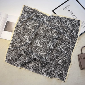 Vue détaillée d'un foulard en soie noir et blanc à motif floral rétro et bordure beige