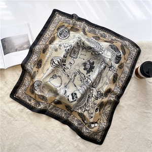 Nahaufnahme des Seiden-Quadrat-Schals mit Kettenmustern auf weichem Plüsch-Hintergrund