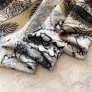Detail eines Seidenschals mit Vintage-Muster und botanischen Drucken auf Plüschstoff