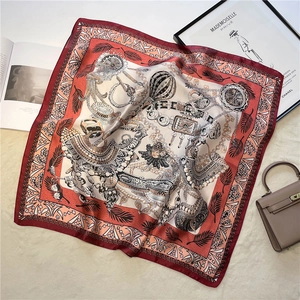 Nahaufnahme eines Vintage-Seidenschals mit Kettenmuster auf beige Plüsch-Hintergrund