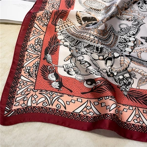 Detail eines Seidenquadrats mit Vintage-Schmuckdrucken und eleganten roten Rändern