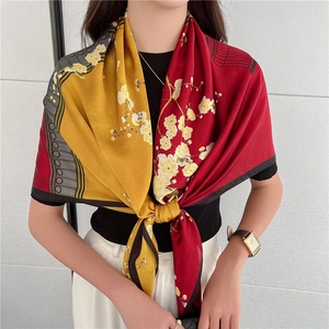 Dettaglio di un foulard di seta di lusso con pannelli rossi e gialli e stampe floreali