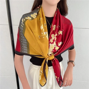 Dettaglio di sciarpa in seta di lusso con stampa fiori di prugno e design bicolore