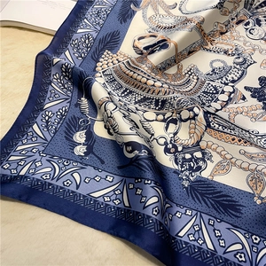 Detail eines Seidenschals mit Vintage-Ketten- und Federmustern auf Satin-Stoff