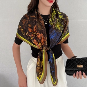 Dettaglio di un lussuoso foulard in seta con stampa floreale e motivi animalier su modella